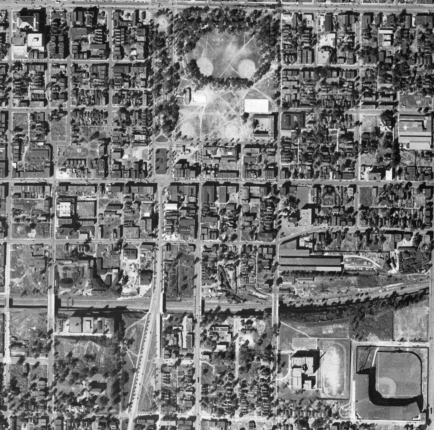 B/W photo of a large area. You can see lots of buildings and trees, with a baseball field in the lower right corner.