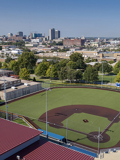 Bird's eye view of a baseball field, with the Kansas City skyline in the distance.